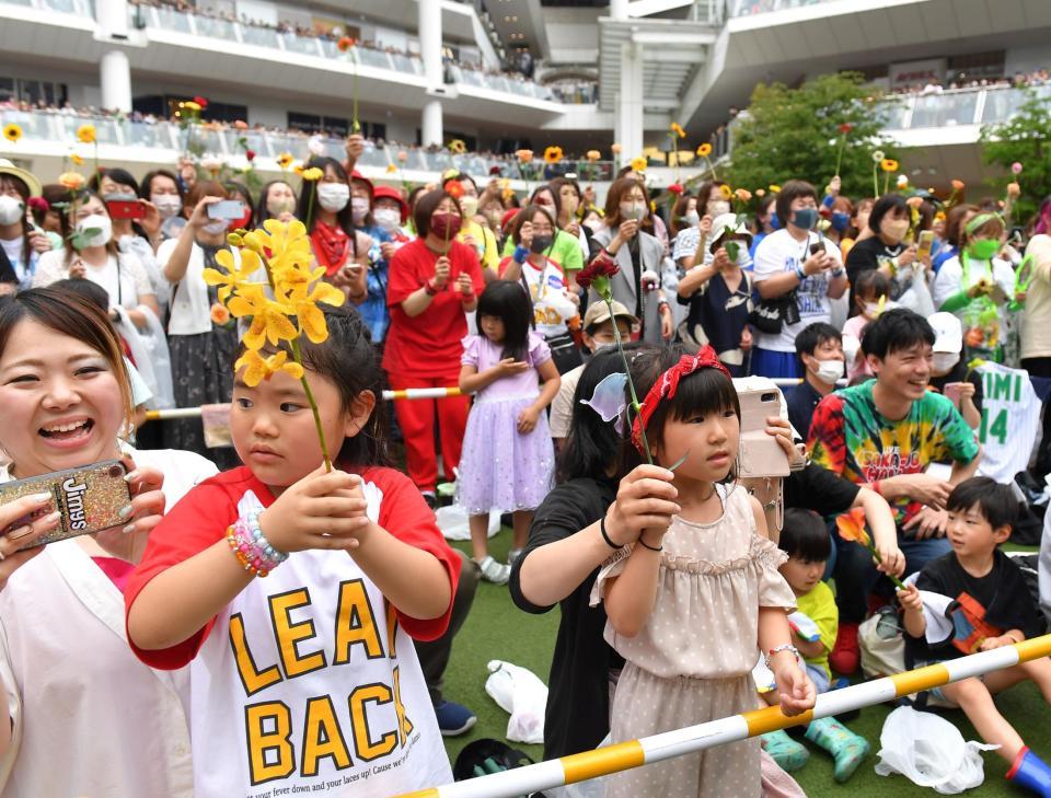 　花を掲げて２６周年を祝福するファン（撮影・出月俊成）