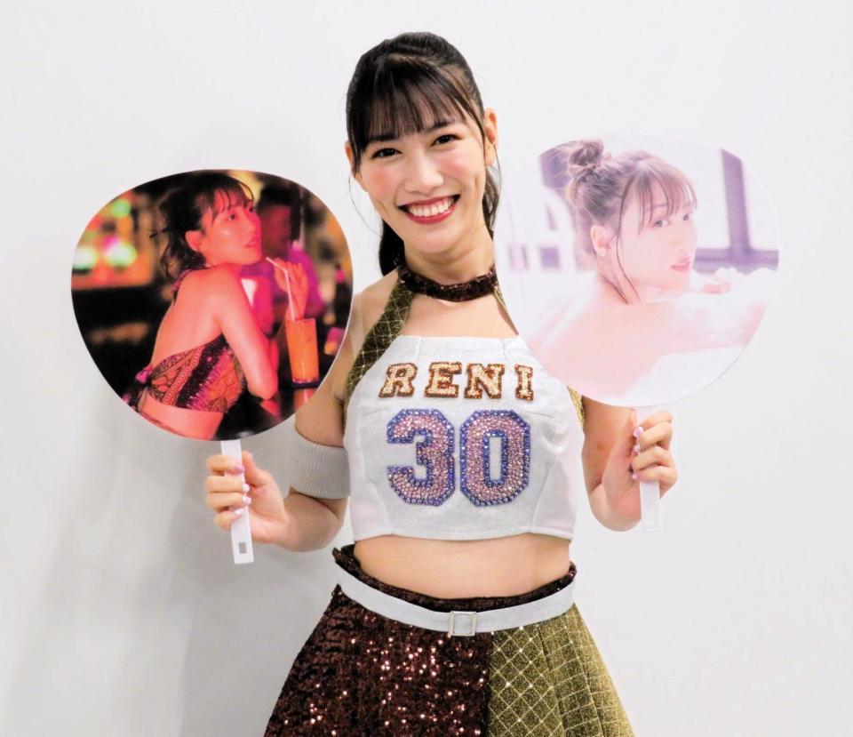 　写真集のカットを貼り付けたうちわを手に笑顔の高城れに