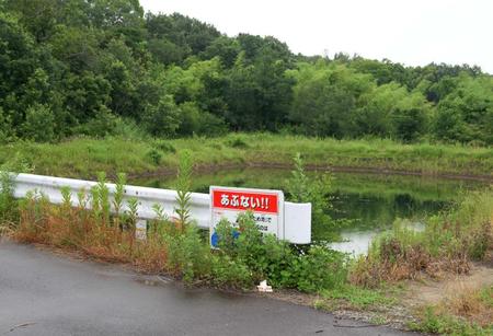 　男児の遺体が遺棄されたとされる現場周辺に置かれたお菓子と花＝６月２６日