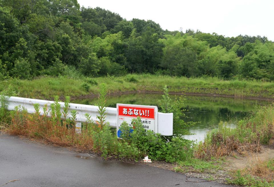 　男児の遺体が遺棄されたとされる現場周辺に置かれたお菓子と花＝６月２６日