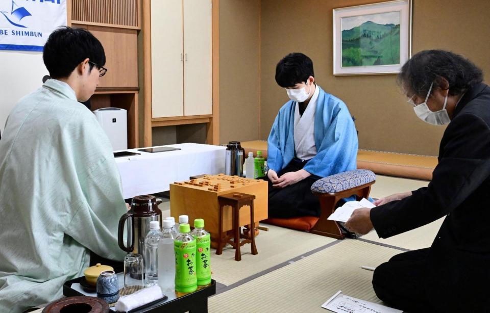 立会人の福崎文吾九段（右端）から封じ手を示される佐々木大地七段（左から２人目）。右から２人目は藤井聡太王位