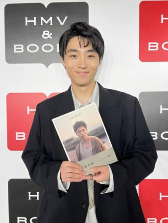 　写真集を手に笑顔を見せるＷＡＴＷＩＮＧの八村倫太郎（撮影・中野修也）