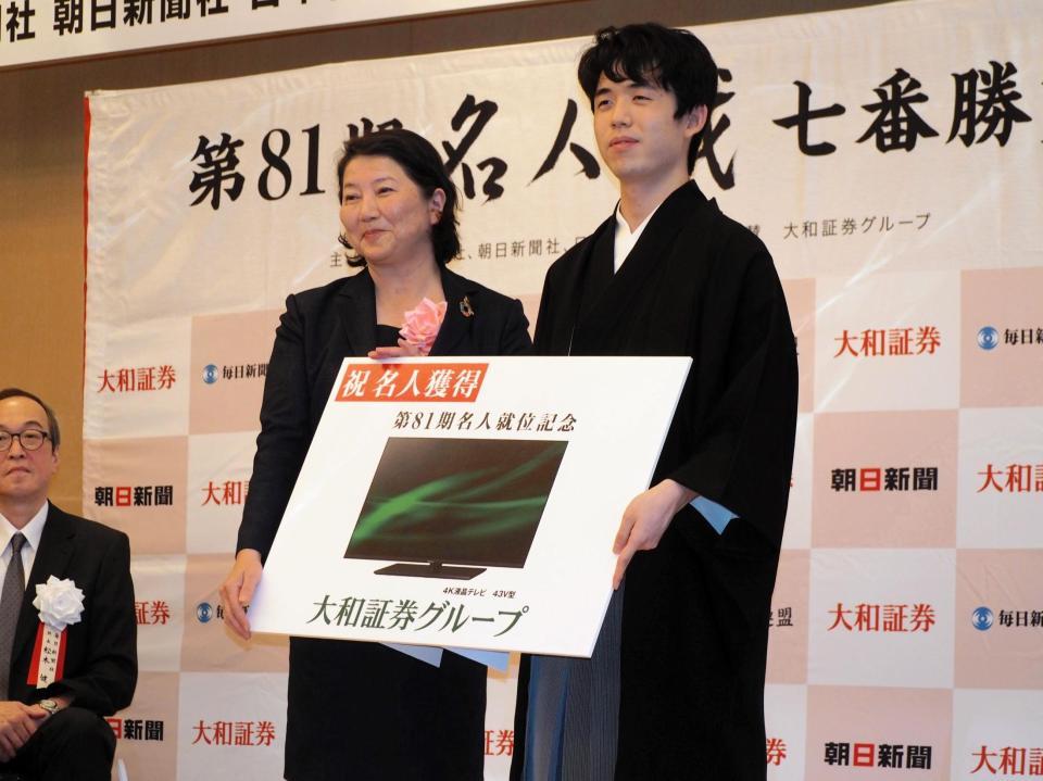 　リクエストした４３インチの４Ｋ液晶テレビを記念品として受け取る藤井聡太名人（右）