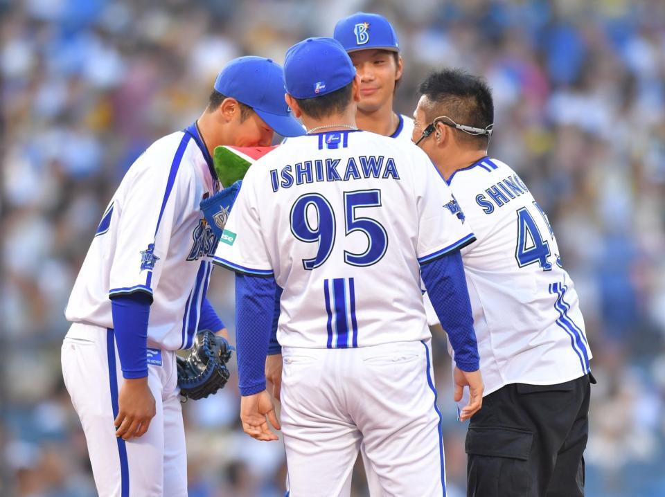 　石川が持ってきたスイカをナインに食べさせる柳沢慎吾（右）＝撮影・西岡正