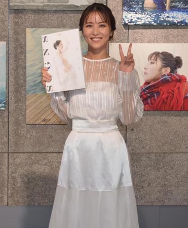 　自信の写真集を手に、笑顔とピースで撮影に応じた石川恋