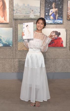 　自信の写真集を手に、笑顔とピースで撮影に応じた石川恋