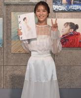 　自信の写真集を手に、笑顔とピースで撮影に応じた石川恋