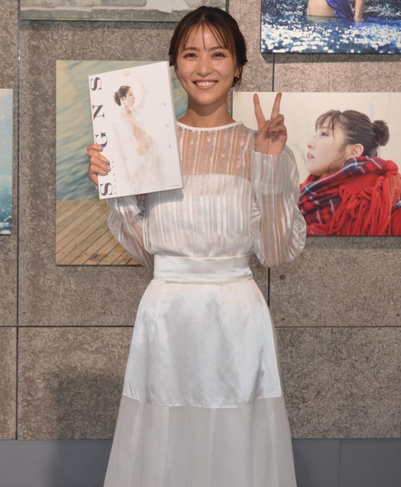 　自信の写真集を手に、笑顔とピースで撮影に応じた石川恋