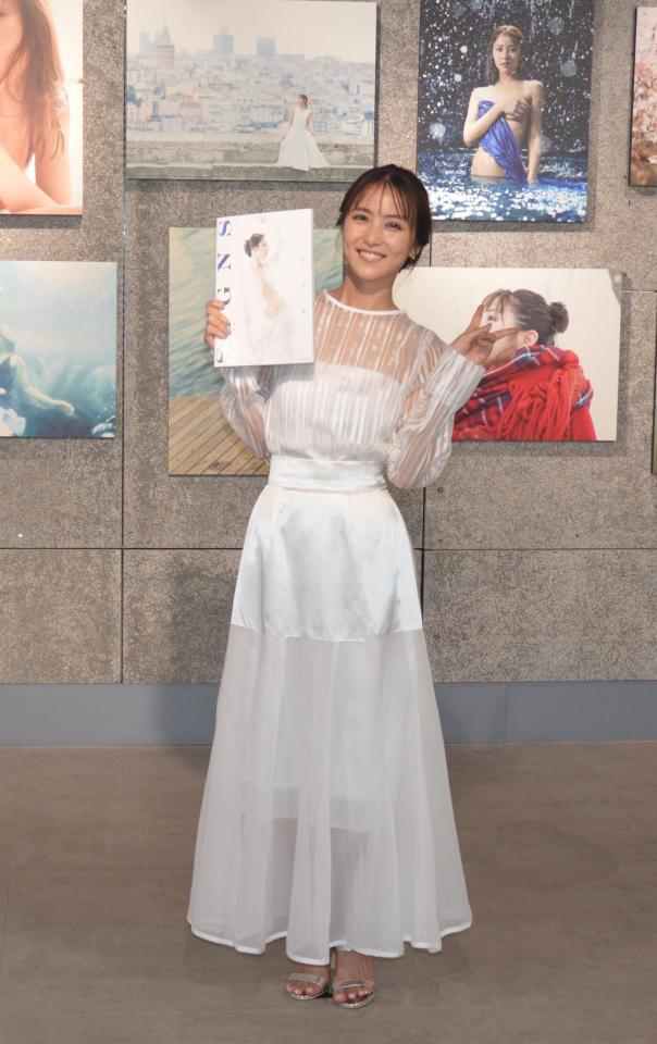 　自信の写真集を手に、笑顔とピースで撮影に応じた石川恋
