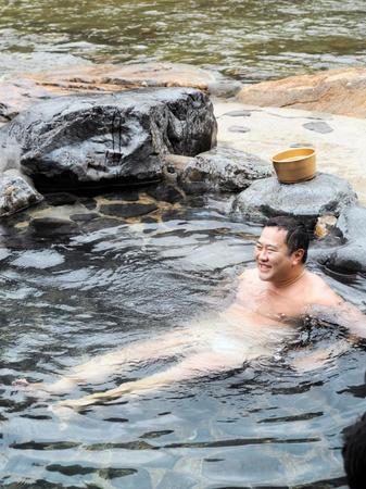 　三朝温泉名物の河原風呂に入浴し、笑顔のとにかく明るい安村