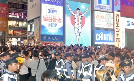 　警察官が厳重に警備する中、歓喜する戎橋に集まったファン