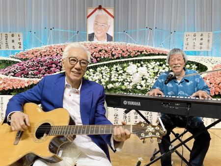 　祭壇の前で弾き語りを披露した荒木とよひさ氏（左）と岡千秋氏