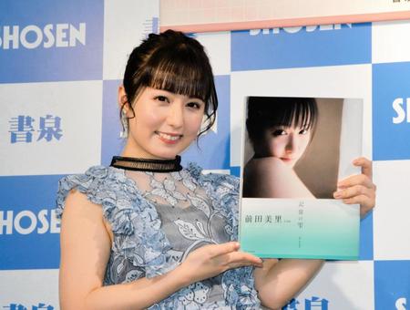 　写真集を手に笑顔の前田美里