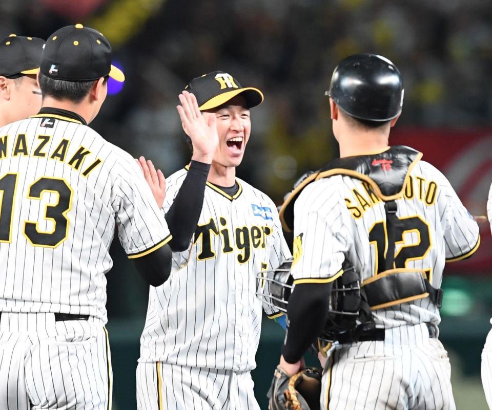　試合に勝利し、ナインとタッチを交わす近本（中央）＝撮影・中田匡峻