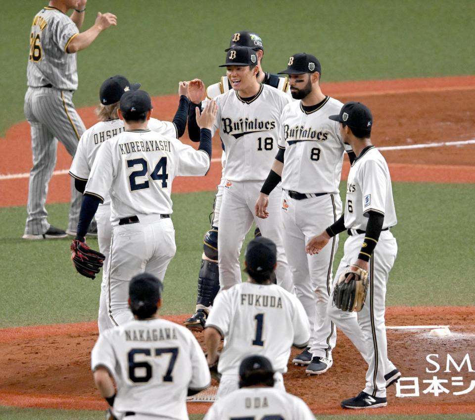 　完投勝利を挙げナインとタッチする山本（撮影・金田祐二）