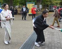 　笑顔でチラシ配りをする林家三平（右）、国分佐智子夫妻