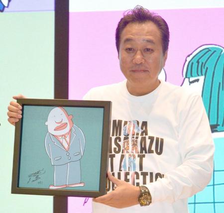 　作品を持つ三村マサカズ