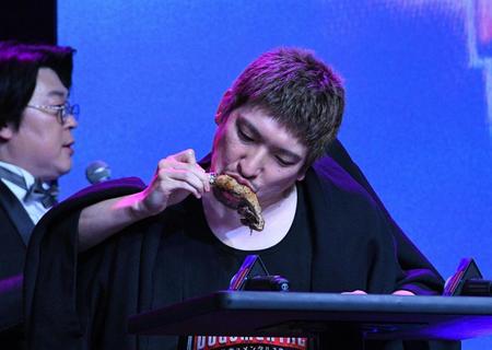 　二人羽織でチキンを食べるＥＸＩＴのりんたろー。（撮影・佐々木彰尚）