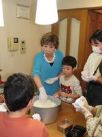 　子どもたちに教えながらおにぎりを作る小林幸子