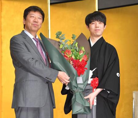 　師匠の杉本昌隆八段（左）から花束を受け取り、笑顔を見せる藤井聡太王座（撮影・西岡正）