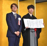 　羽生善治会長（左）の横で允許状を持ち、笑顔を見せる藤井聡太王座（撮影・西岡正）