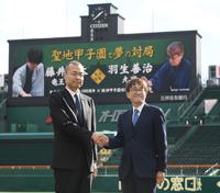 　１２月８日に藤井聡太竜王・名人と甲子園での対戦が決まった羽生善治九段（右）は阪神甲子園球場長の向井格郎と握手を交わす（撮影・中田匡峻）