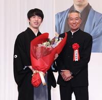 　柳葉敏郎から花束を受け取り笑顔の藤井聡太竜王（撮影・金田祐二）