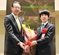 　濱田剛史高槻市長から花束を受け取った藤井聡太王将（右）