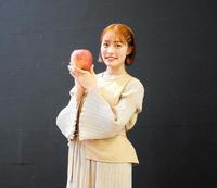 　大きな品種のりんご「世界一」を手にした王林