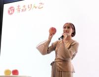 　大きな品種のりんご「世界一」を手にした王林