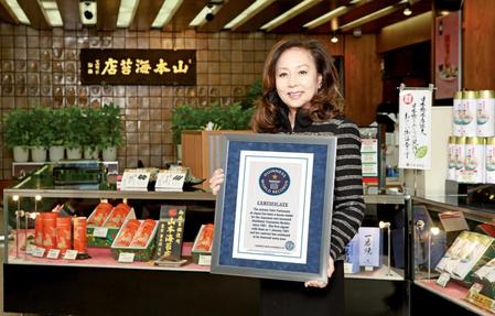 　山本海苔店でギネスの賞状を掲げる山本陽子さん＝２０１０年