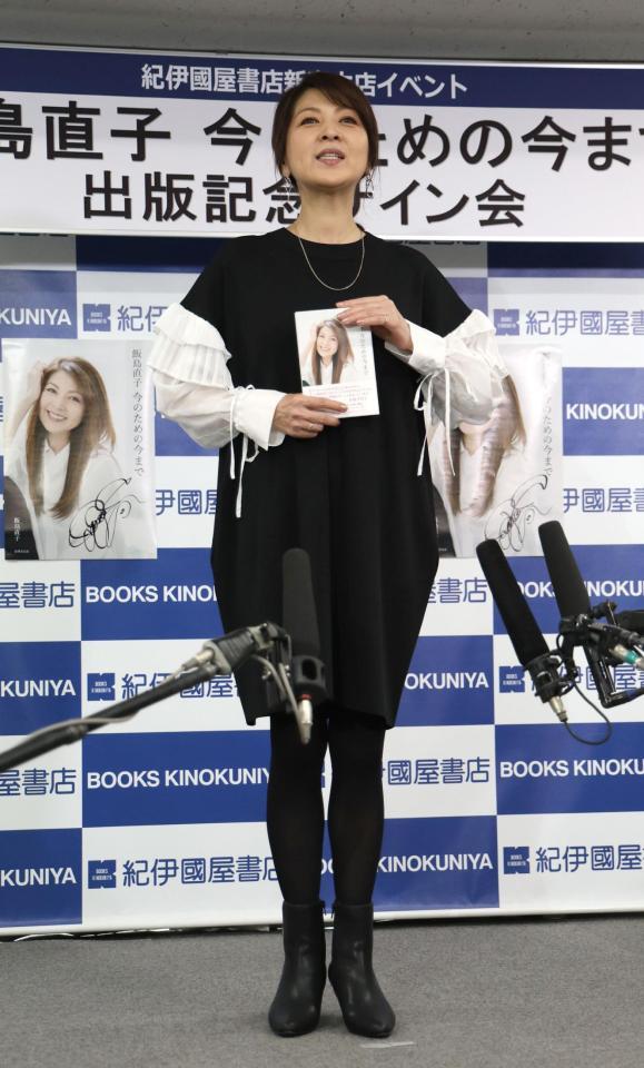 　本を手にする飯島直子（撮影・西岡正）