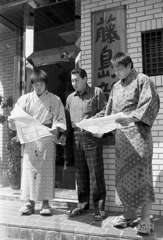 夏場所番付発表で初めて自分の名前が載った番付を見入る（左から）若花田、藤島親方、貴花田＝１９８８年（昭和６３年）４月２４日