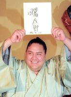 　１９９６年４月、帰化が認められ、記者会見で日本人名を書いた色紙を掲げて笑顔の横綱曙
