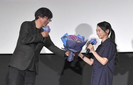 　夫の山崎貴監督（左）から花束を受け取る佐藤嗣麻子監督（撮影・佐々木彰尚）