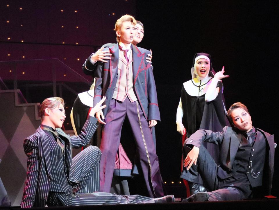 　「３９　Ｓｔｅｐｓ」でハネー（凪七瑠海）の肩を抱く頬に傷のある牧師（叶ゆうり）ら