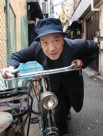 　自転車のハンドルを握り、ポーズを取る唐十郎さん＝２００４年５月