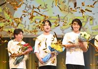 　金色のテープが舞う中、グランプリ受賞がコールされた黄兆銘さん（中央）＝撮影・園田高夫