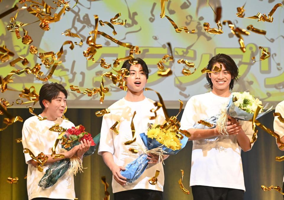 　金色のテープが舞う中、グランプリ受賞がコールされた黄兆銘さん（中央）＝撮影・園田高夫