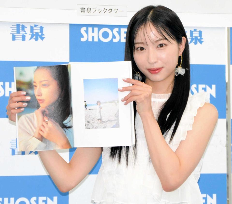 　写真集を手に笑顔の林佑香