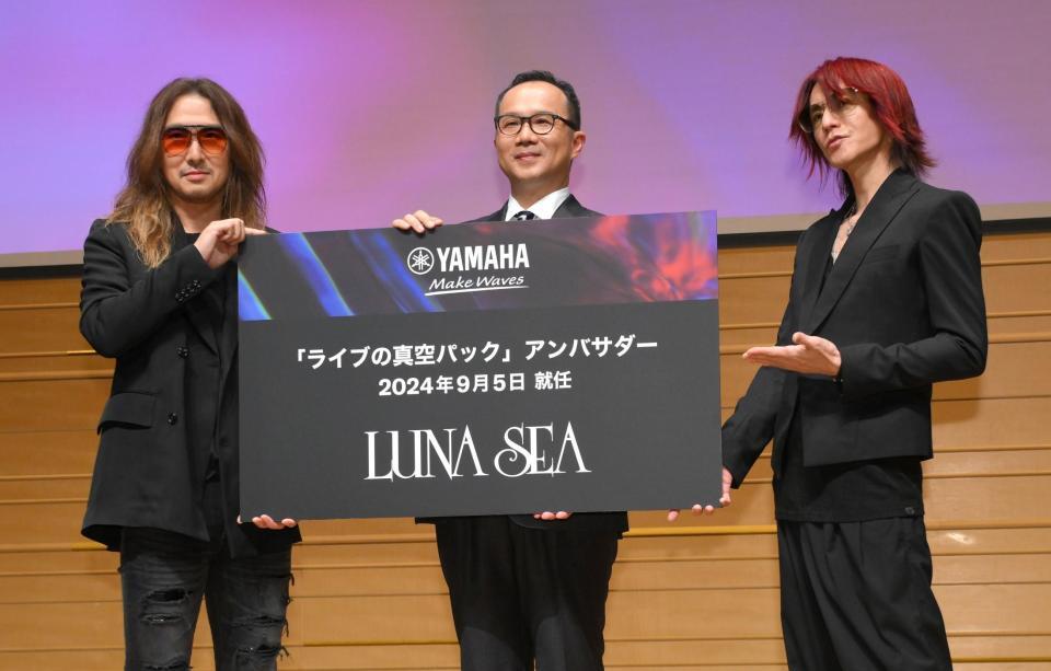 　山浦敦社長（中央）からヤマハ「ライブの真空パック」アンバサダーに任命されたＬＵＮＡ　ＳＥＡのＪ（左）とＳＵＧＩＺＯ（ＲＹＵＩＣＨＩは体調不良のため欠席）＝撮影・伊藤笙子