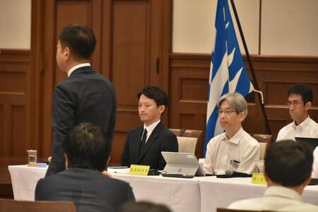 　自身の前を取って不信任決議案の投票に向かう議員を見つめる斎藤元彦兵庫県知事（中央）