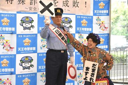 　署員とともに特殊詐欺への注意喚起を行う松平健（左）