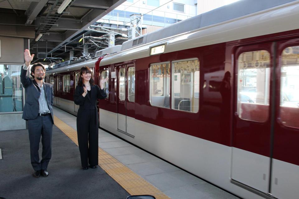 　近鉄桑名駅を発車する電車を見送る草野翔吾監督（左）と黒木華