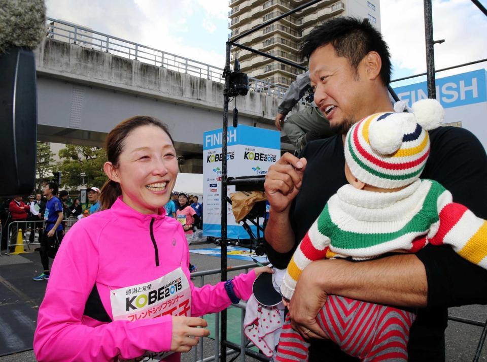 　ゴール地点で夫のマック鈴木さんと子ども（右）の出迎えを受け、笑顔の小原正子さん＝２０１５年１１月