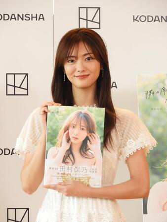 　写真集を手に笑顔を見せる櫻坂46の田村保乃