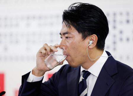 　メディアのインタビューの合間に水を飲む自民党の小泉選対委員長＝27日午後８時24分、東京・永田町の党本部