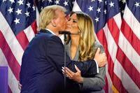 　米フロリダ州の集会会場で、妻のメラニアさん（右）とキスするトランプ前大統領＝６日（ＡＰ＝共同）