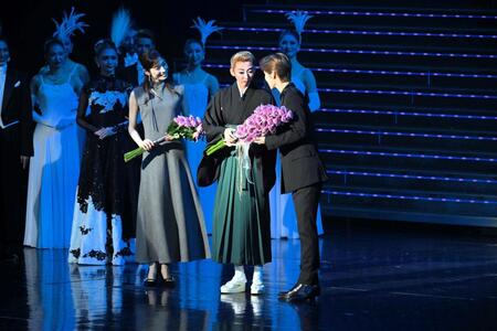 　同期の元花組トップ明日海りお（左）と専科の瀬央ゆりあから花束を贈られる凪七瑠海（中央）＝撮影・石井剣太郎