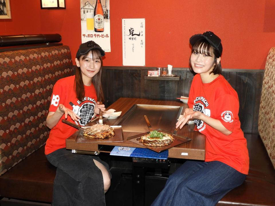 　自身が考案したお好み焼きを前に笑顔を浮かべる杉本愛里（左）と高橋凛